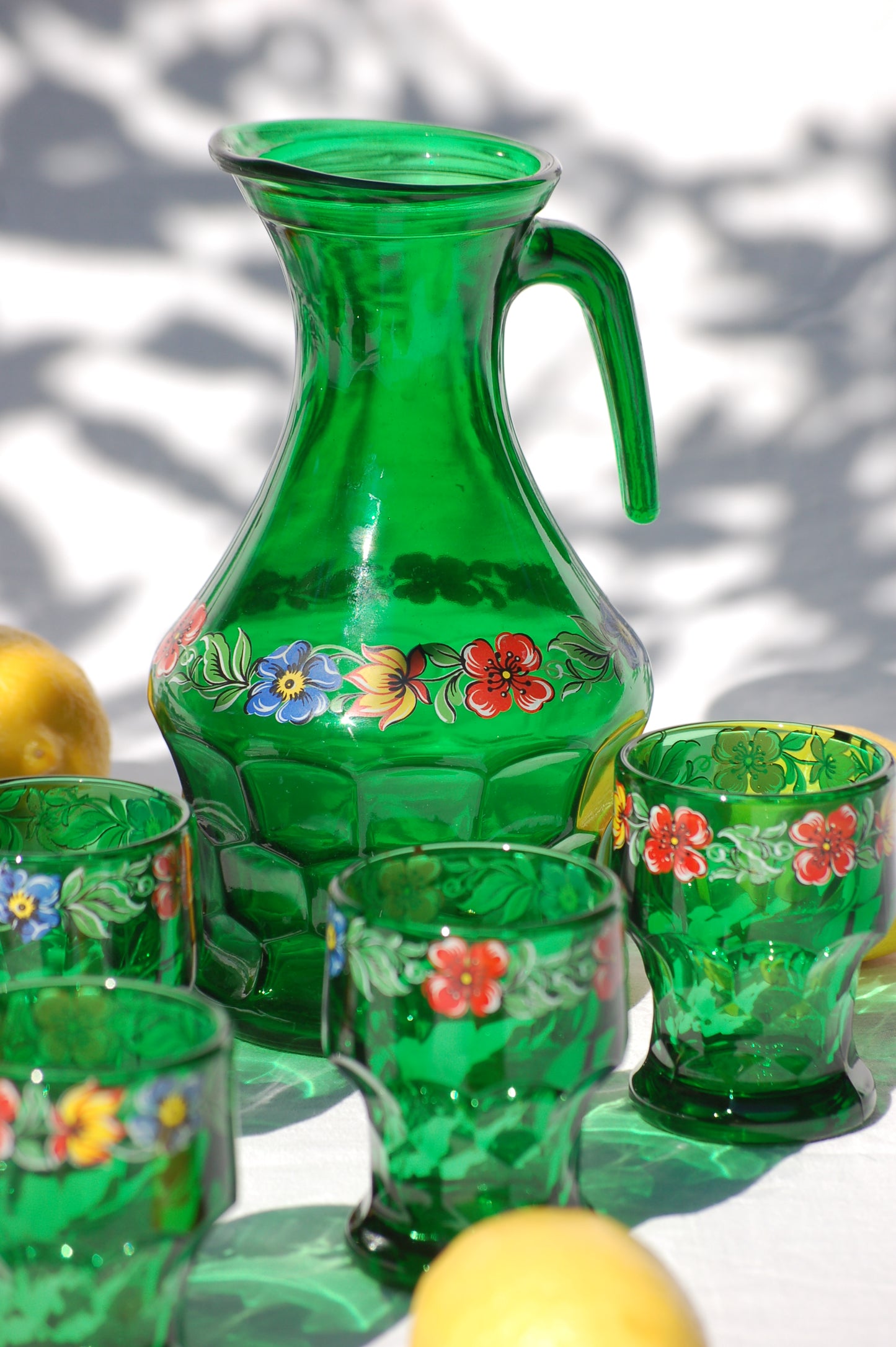 Rare Italian vintage emerald green glass set carafe and tumblers Bormioli Italy by Mediterrastyle. ©mediterrastyle This Italian emerald glass carafe and tumbler set is an iconic Italian piece of design. The historic Bormioli factory created this sculptured line of tumblers and caraffes in the late 1960's , and this particular version was a rare variation of the 1970s. It is decorated with a flower pattern, and it is rather rare to find a complete set from that era. Loved and sold by Mediterra Style.